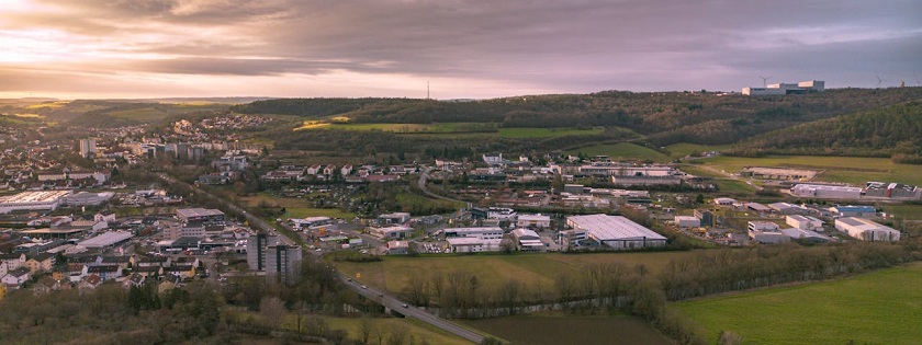 Ausblick auf einen Ortsrand und ein Gewebegebiet. 