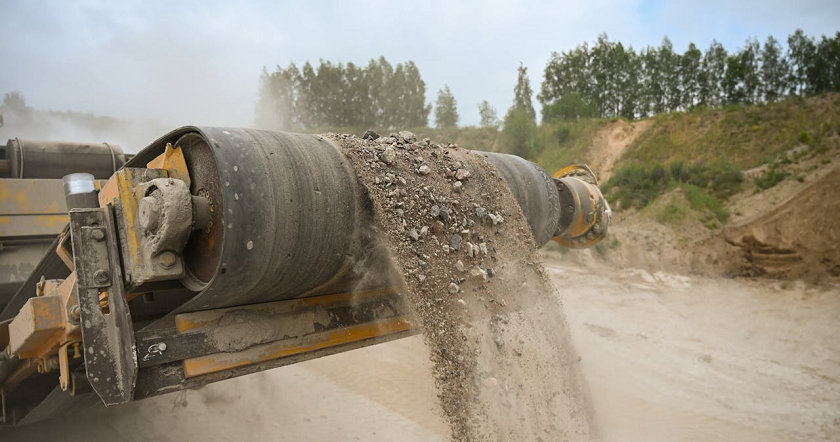 Förderung von Kies in einem Kieswerk durch ein Baugerät.